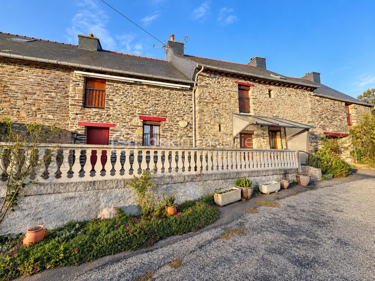 Maison rurale en pierre sous soleil éclatant.png