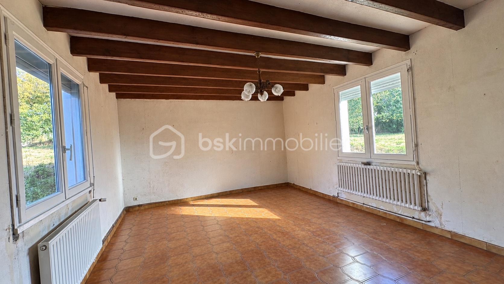 Salon rustique vide baigné de lumière naturelle.jpg