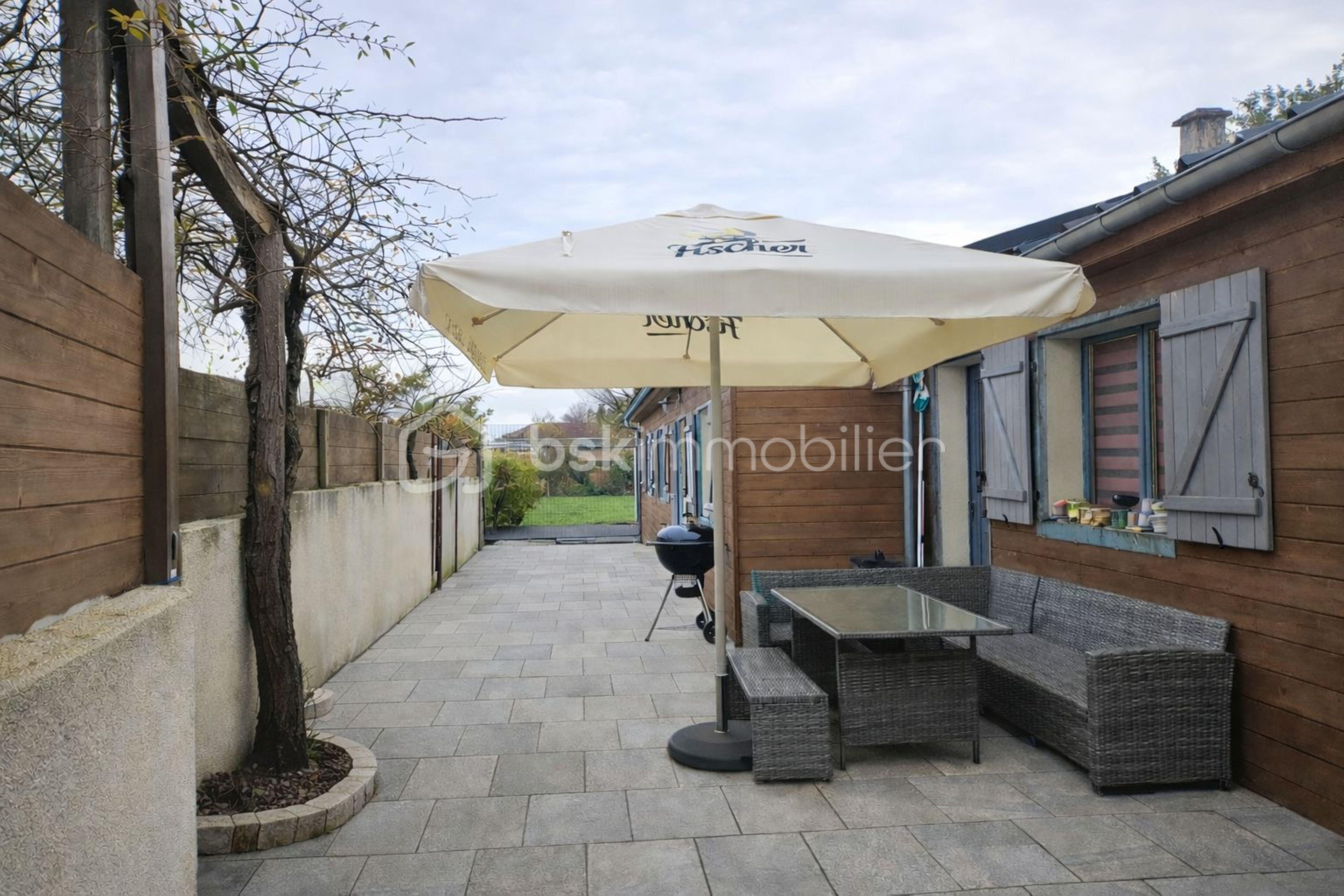 Maison de 121 m² - Patio avec parasol et jardin verdoyant.jpg