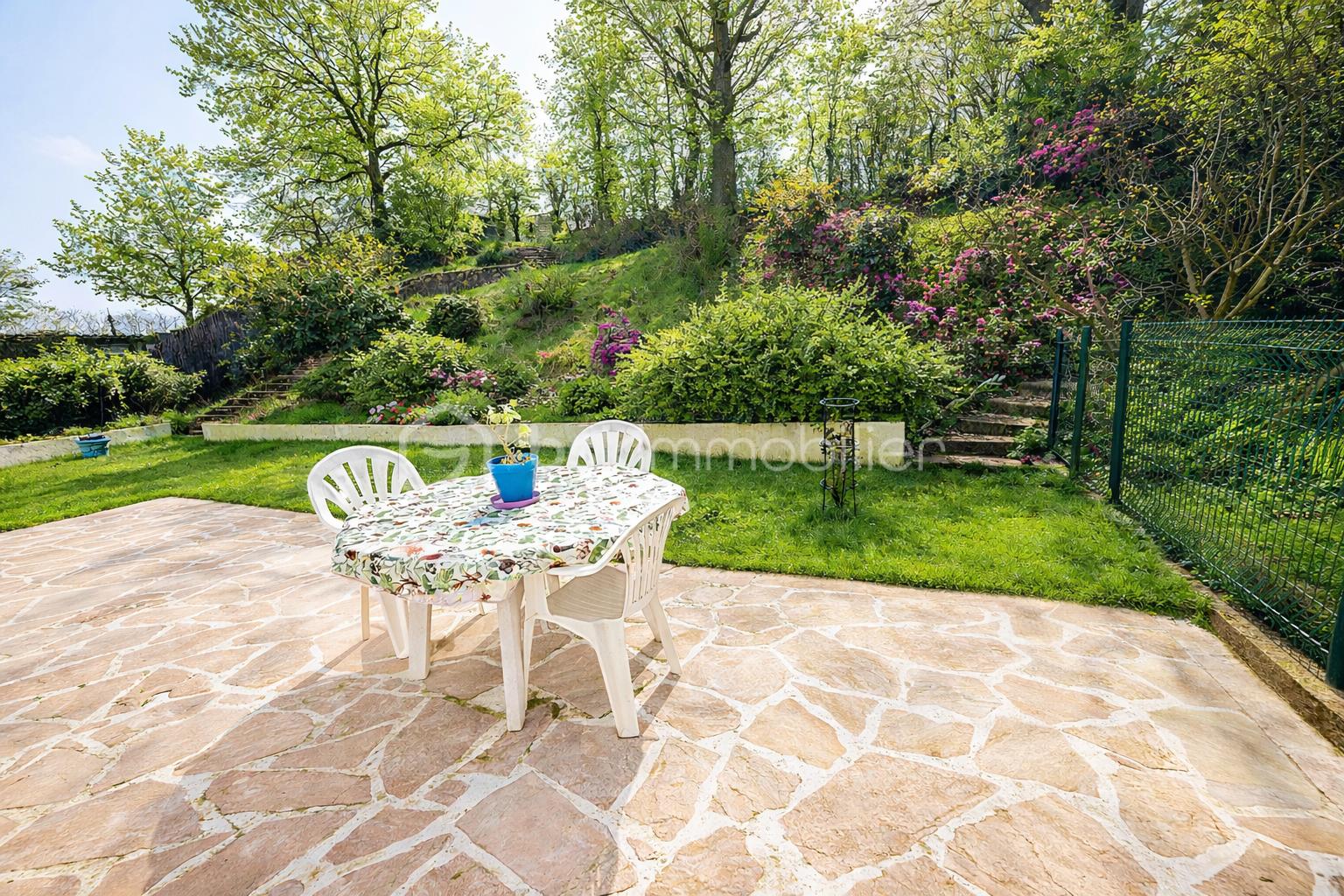 Jardin ensoleillé avec table et plantes.png