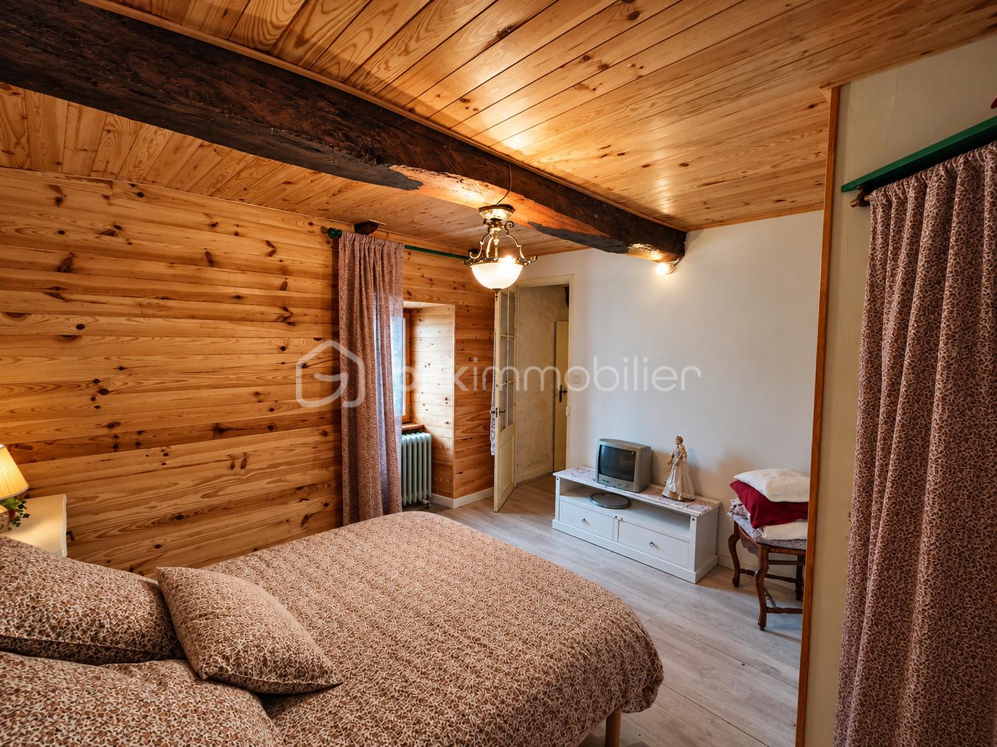 Chambre rustique chaleureuse sous poutre en bois.png