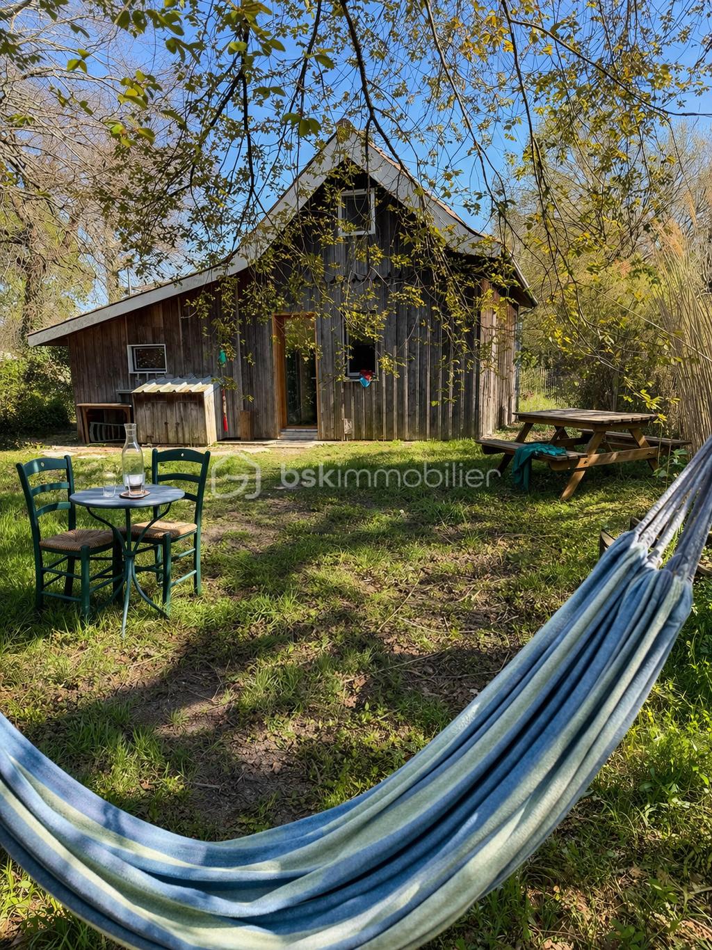 Jardin ensoleillé et maison en bois.png