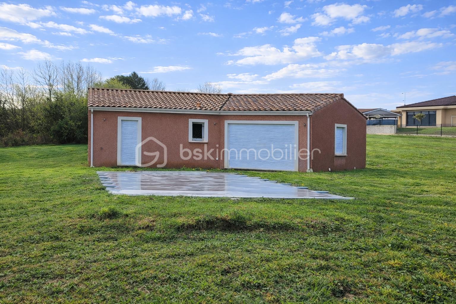 Bâtiment rouge dans un jardin verdoyant.png