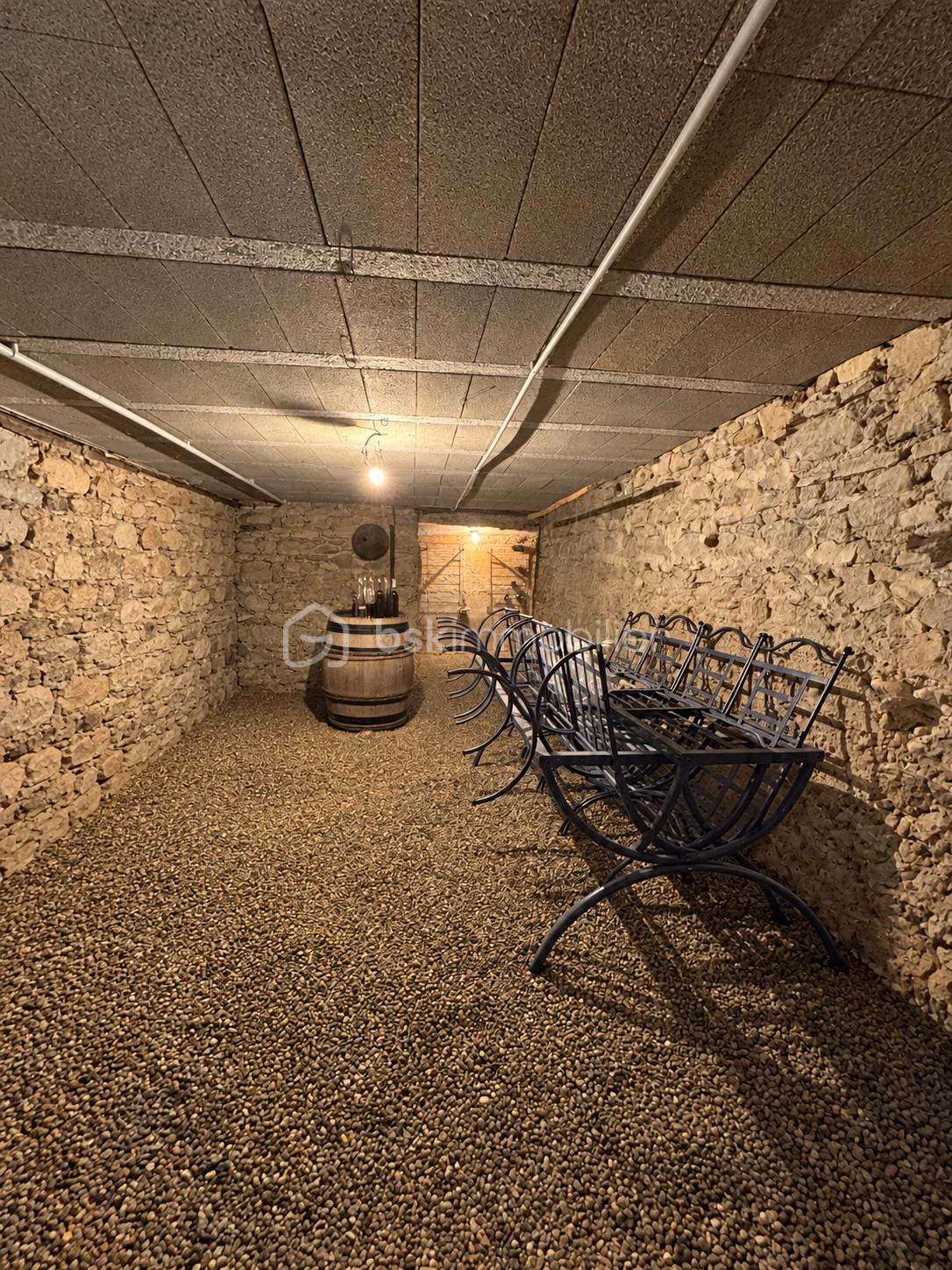 Cave voûtée avec tonneau et chaises.png