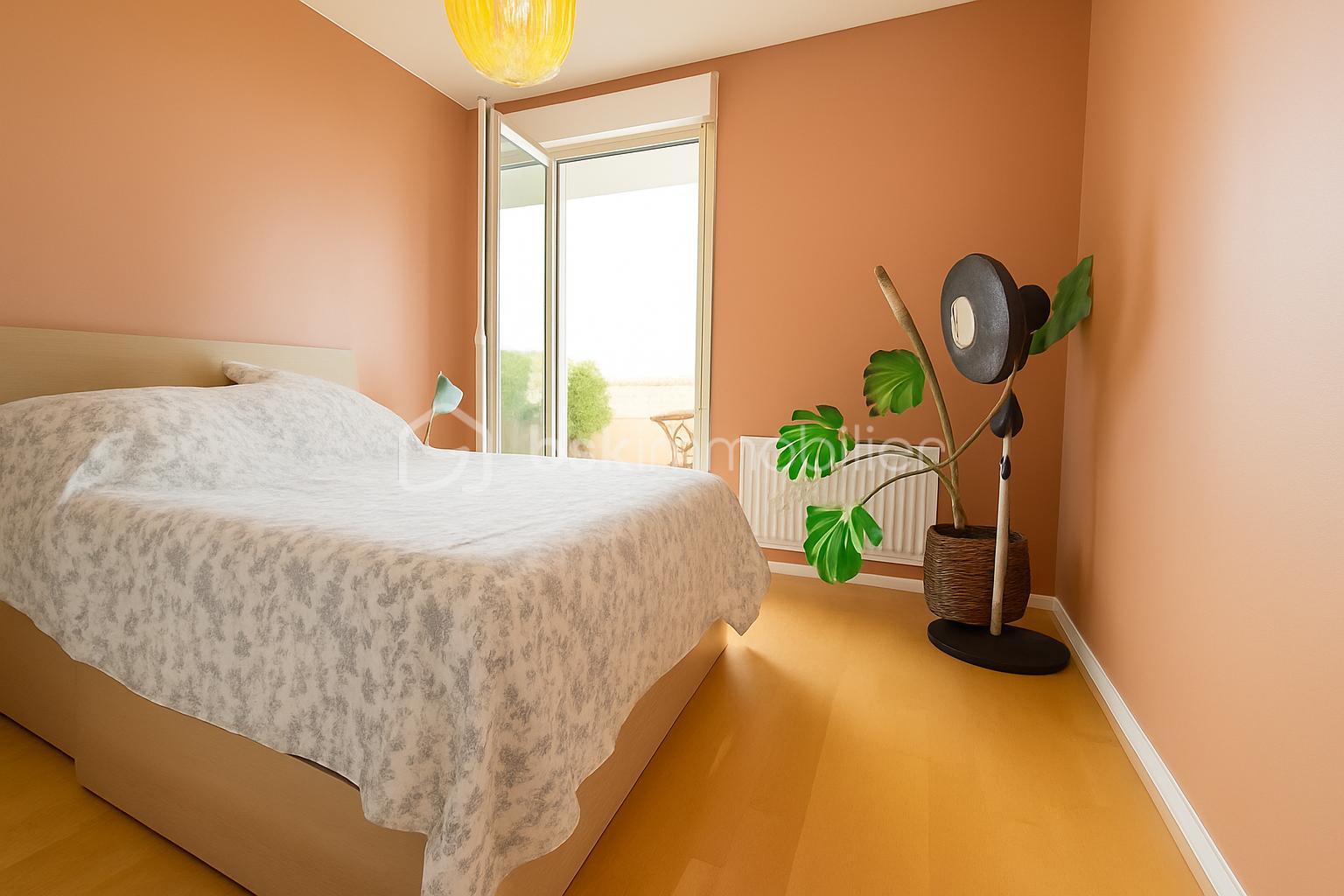 Appartement de 68 m² - Chambre lumineuse avec balcon et plantes.png