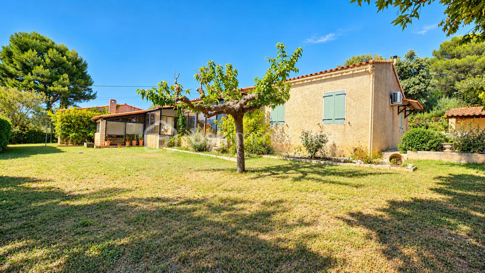 Maison méditerranéenne au jardin ensoleillé.png