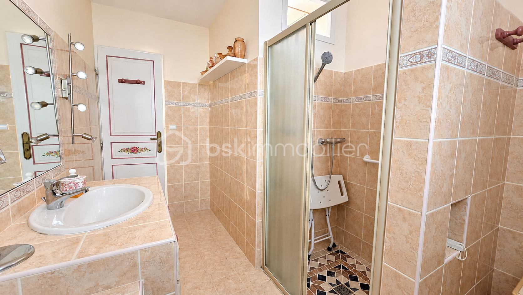 Salle de bain chaleureuse avec douche vitrée.png