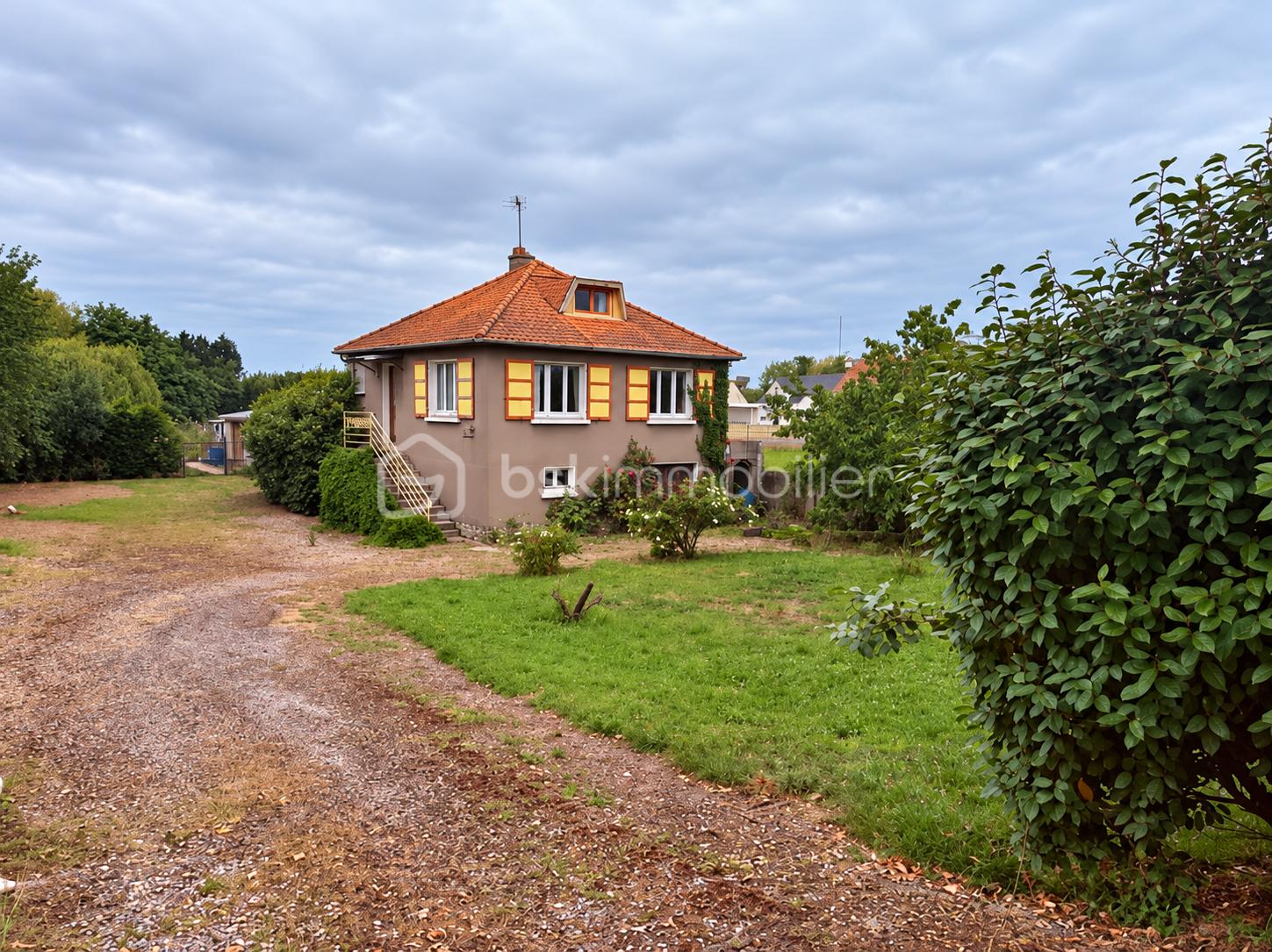 Maison et jardin sous ciel nuageux.png