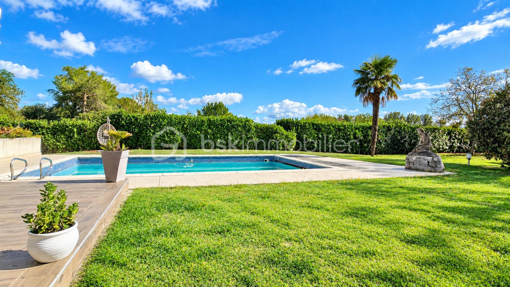Jardin ensoleillé avec piscine et palmiers.png