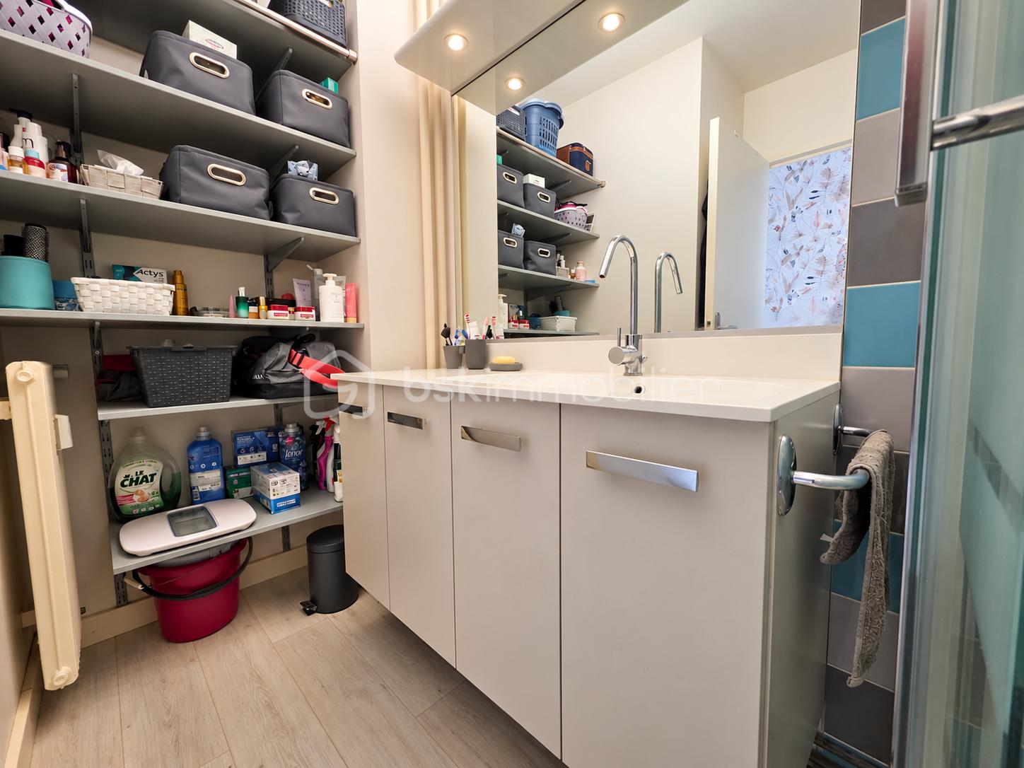 Salle de bain moderne avec rangements gris.png